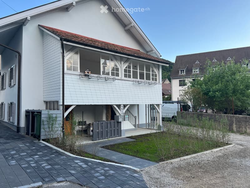 House. Modern white house with a red roof, large windows, and a small garden in front.