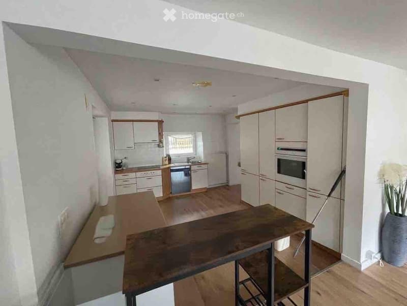 modern kitchen with wooden table, white cabinets, stainless steel appliances, dishwasher