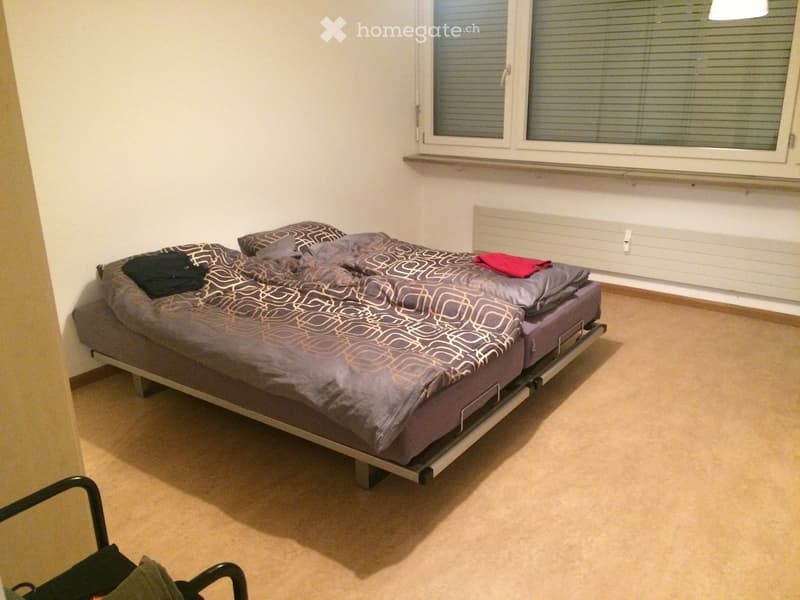 Bedroom with a single bed, patterned duvet, pillows, and a radiator under the window.
