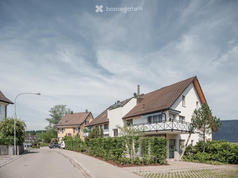 3 houses, brown roofs, white walls, balcony, hedges, street