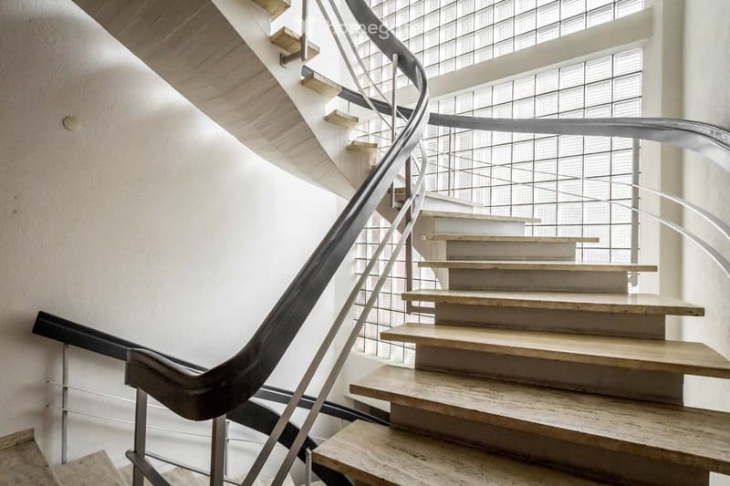 Marble staircase with wooden steps and metal handrails