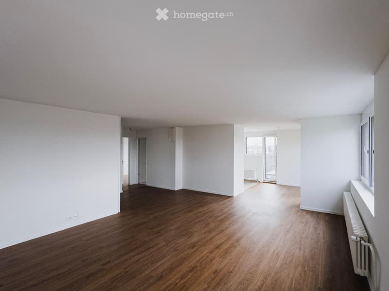 Empty room with wooden floor, white walls, and white ceiling.
