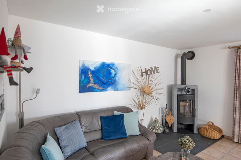 leather couch, pillows, plant, fireplace, artwork, wooden storage basket