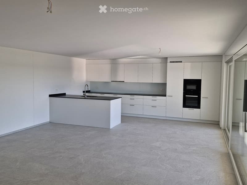Modern kitchen with white cabinets, a central island, and built-in appliances including a sink and oven.