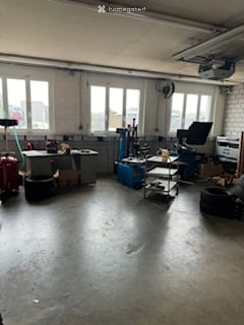 Unfurnished Room. Empty industrial-style room with large windows, concrete floor, and scattered tools and equipment.