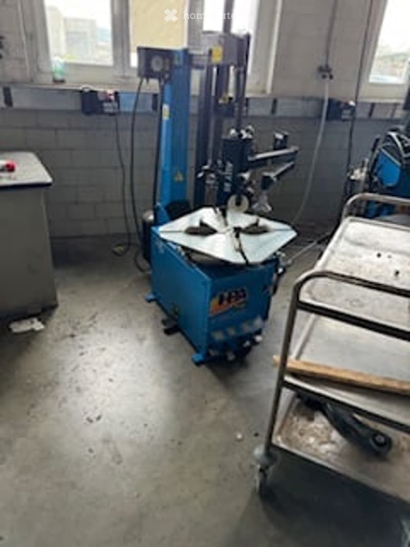 Unfurnished Room. Empty workshop or garage space with concrete floor, windows, and industrial equipment partially visible.