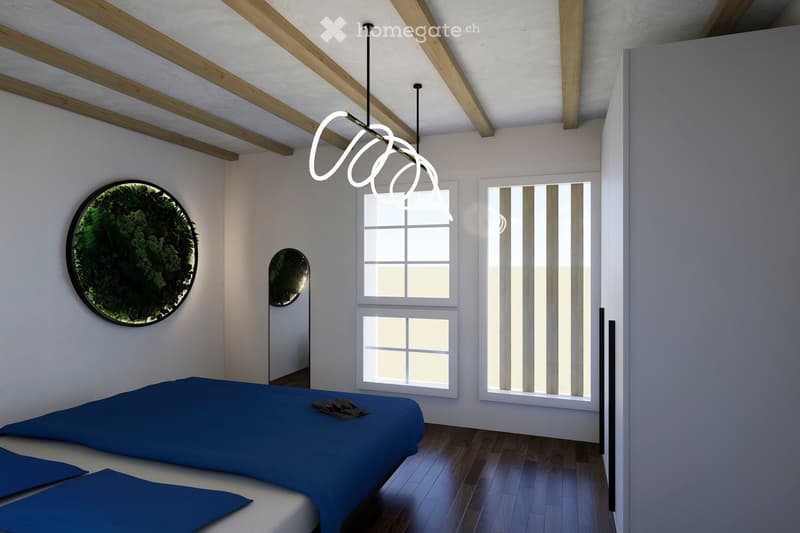 Modern bedroom with a blue bed, wooden floor, large windows, and a round wall-mounted mirror with a leafy design.