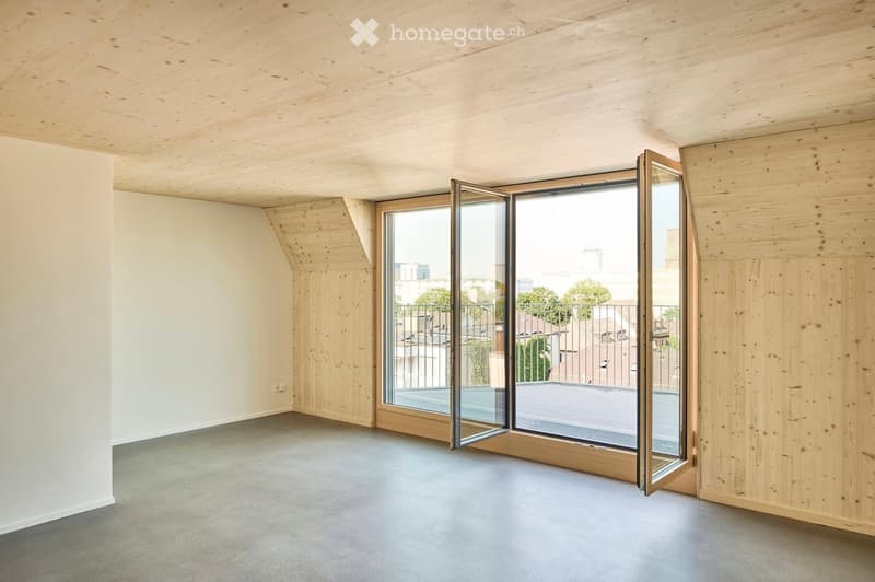 Empty room with wooden walls and ceiling, large sliding glass doors leading to a balcony or terrace area.