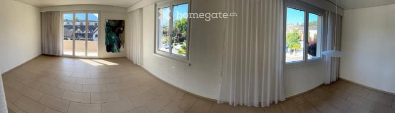 Empty room with large windows, tiled floor, and white walls. No furniture or equipment present.