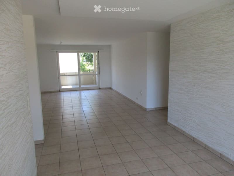 Empty room with tiled floor, white walls, and a large glass door leading to a balcony.