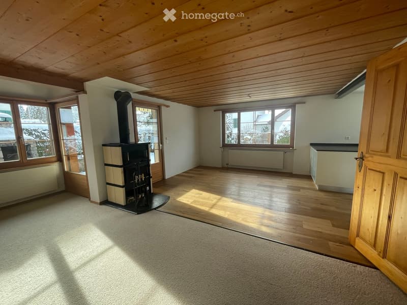 Empty room with wooden ceiling, wooden floor, large windows, and a fireplace.