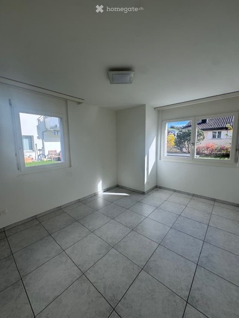 Empty room, tiled floor, windows, light fixture on ceiling