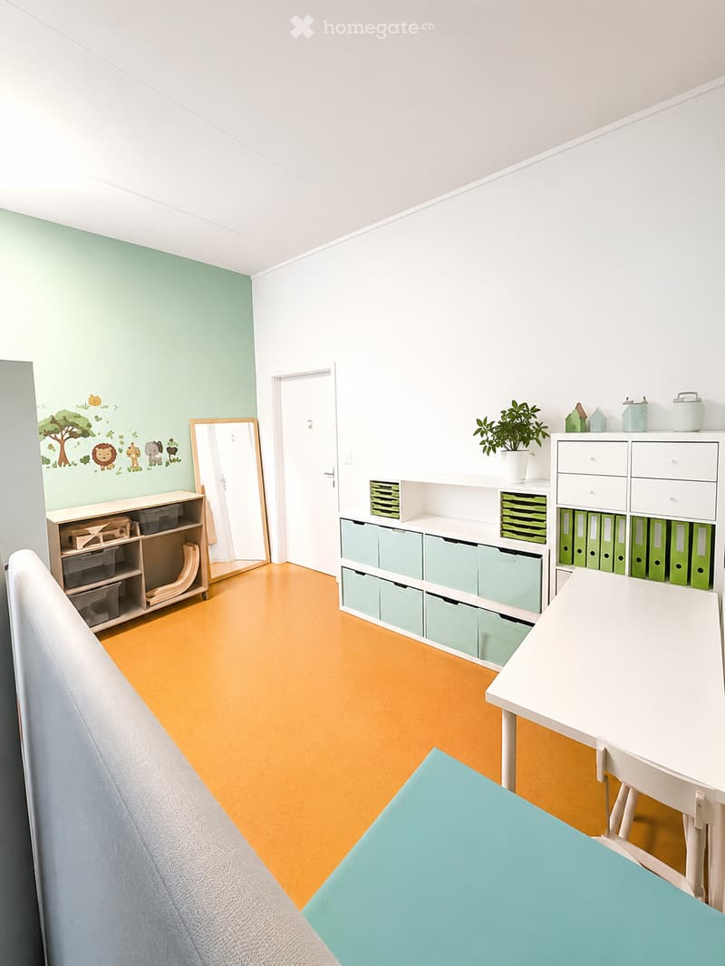 Bright, organized room with a white table and chair, shelves with storage bins, a mirror, and a small plant on a shelf.