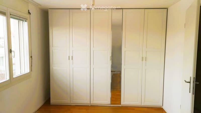 Empty room with built-in wardrobe, glass window, wooden floor