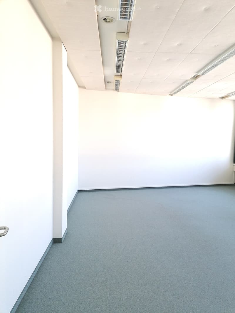 empty room, white walls, gray floor, square ceiling tiles, ceiling lights, air vents