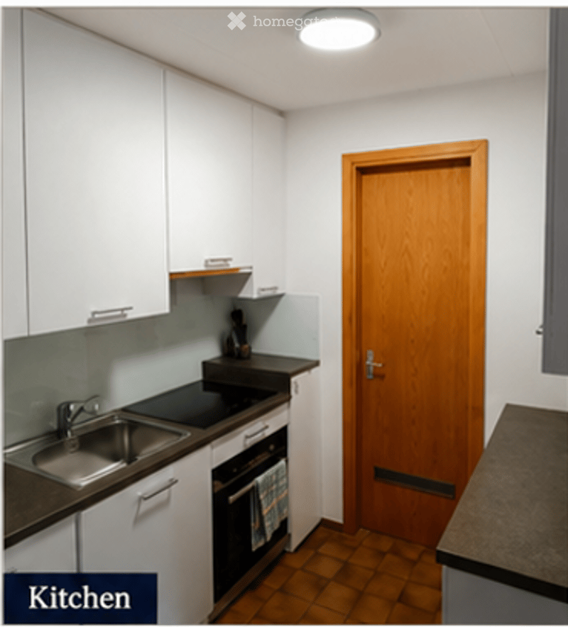 Modern kitchen with white cabinets, stainless steel sink, oven, and wooden door.