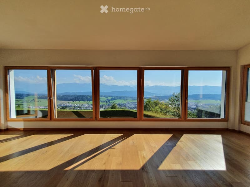 large windows, wooden floor, view of mountains and town