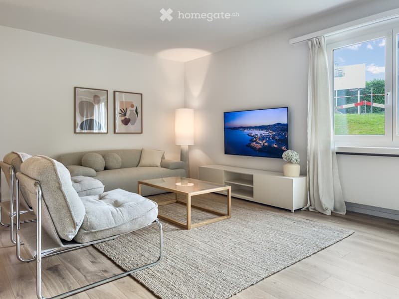 Modern living room with a sofa, coffee table, armchair, floor lamp, television, and decorative artwork on the walls.