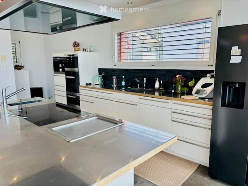 Modern kitchen with white cabinets, stainless steel appliances, and a large island countertop.