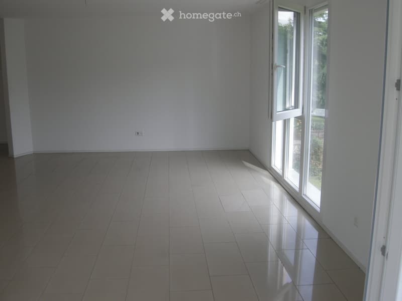 Empty room with tiled floor and large sliding glass door leading to outdoor area.