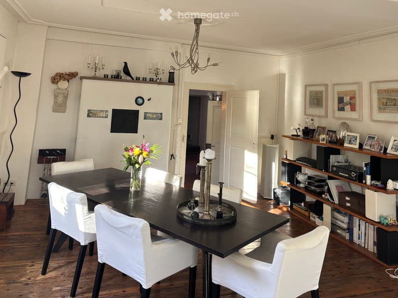 Black dining table, white dining chairs, flower vase, chandelier