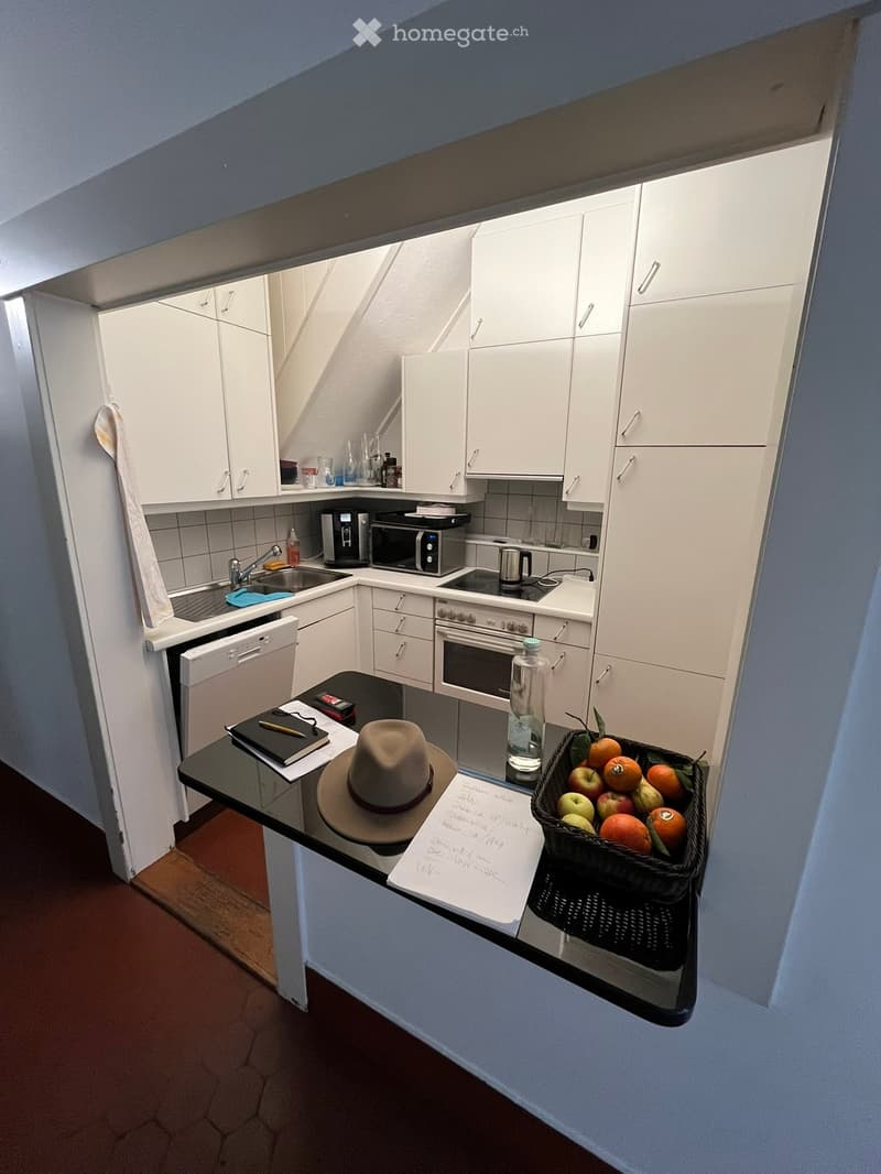 open plan kitchen with countertops, dishwasher, white cabinetry, sink, oven, dishwasher, black countertop, basket of fruit, modern appliances