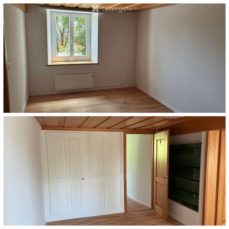 Two unfurnished rooms with wooden floors, white walls, and large windows. The first room has a radiator and a window with a view of greenery. The second room features a white closet and an open doorway leading to another space.