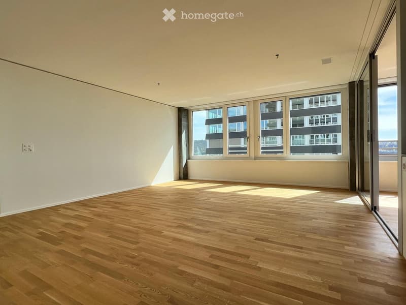 Empty room with wooden flooring and large windows, no furniture or equipment present.