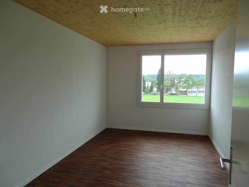 empty room, hardwood floors, white walls, wooden ceiling, large window with green view