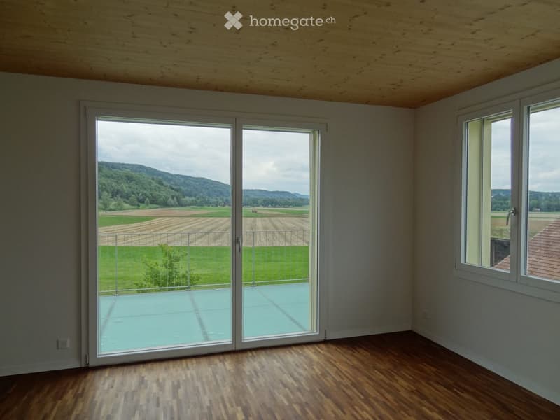 large windows, sliding glass door to balcony, wooden floor, no furniture