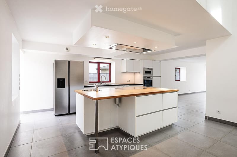 Modern kitchen with white cabinets, stainless steel appliances, and a central island with wooden countertop.