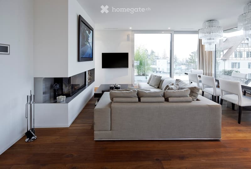Fireplace, large windows, tv mounted on wall, wooden floor, large sofa, dining table with chairs