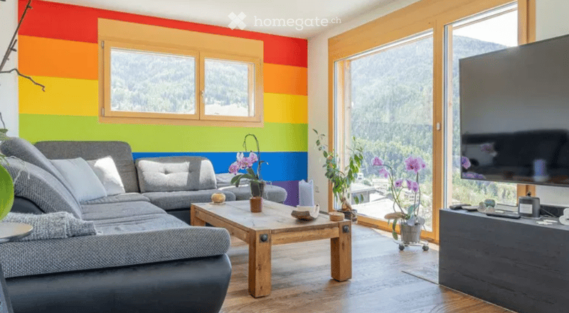 two sofas, coffee table, TV, plants, wooden floor, colorful walls, large windows