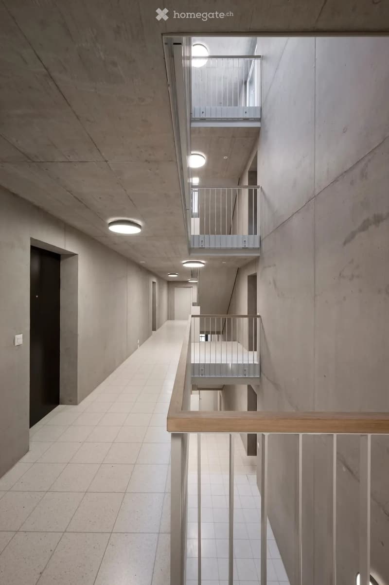 modern building, concrete walls, white tiled floor, metal handrails, balconies