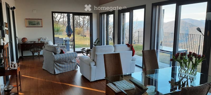 2 white sofas, 2 brown chairs, dining table, rug, large windows with views