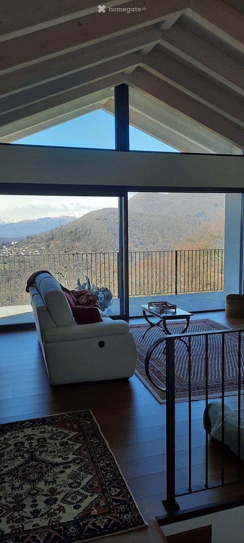 large sofa, glass windows, balcony, carpet, table, balcony railing