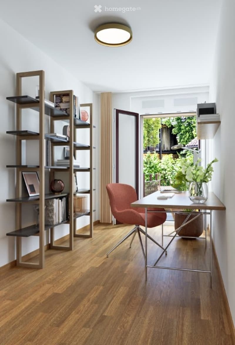 A modern, well-lit study or home office with a wooden floor, a sleek desk with a chair, a tall wooden bookshelf filled with books and decorative items, and a vase with white flowers on the desk. The room features large windows with sheer curtains, allowin