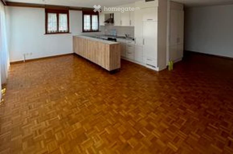 Empty room with wooden flooring, white walls, and a large window. No furniture or equipment present.