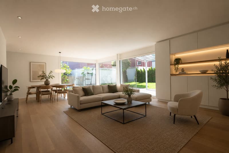 Modern living room with light-colored sofa, coffee table, dining area, pendant light, and large windows overlooking a garden.