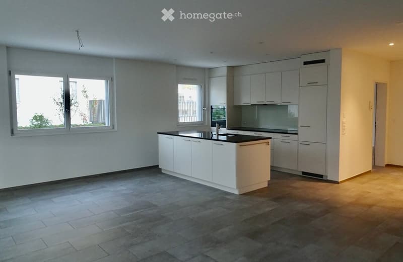 Modern kitchen with white cabinets, a central island, and a black countertop. The space features large windows and a tiled floor.
