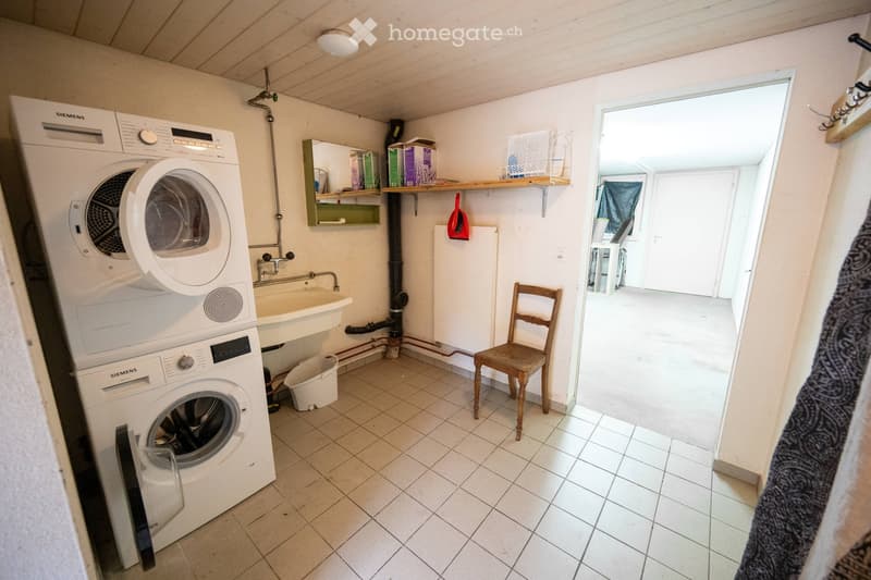 washer, dryer, washing sink, wooden chair, and white tiles