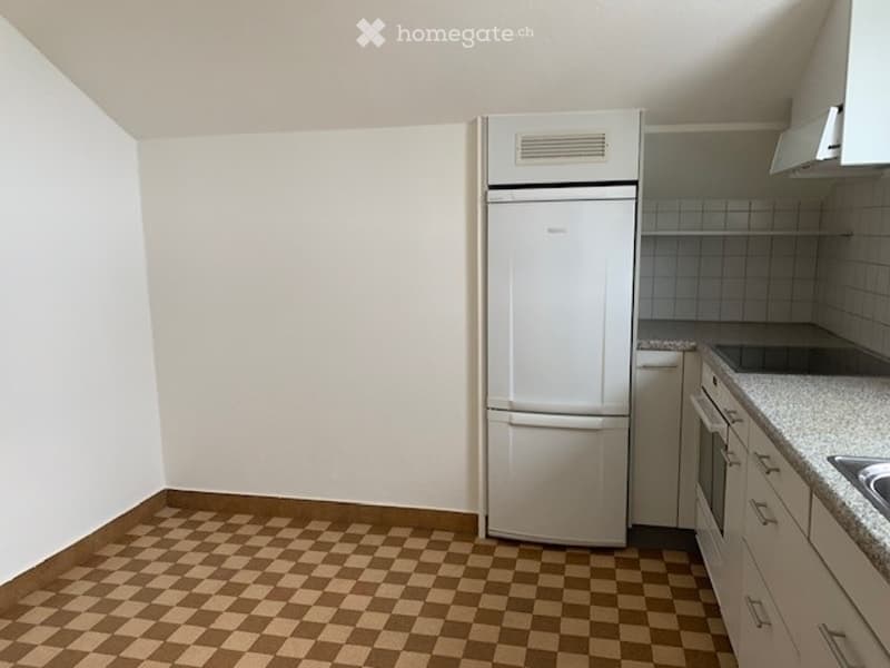 A small kitchen with a checkered floor, white refrigerator, oven, and cabinets.