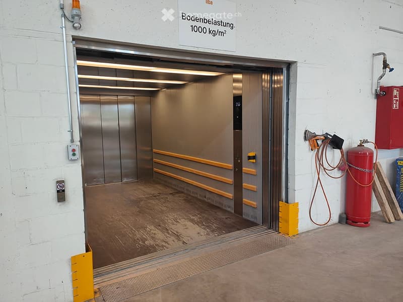 {"visible_features": ["Garage"], "type": "Garage", "objects": [], "description": "Garage with a large, open elevator door leading into a spacious, well-lit interior. The floor is made of polished concrete, and the walls are white brick. Safety equipment,