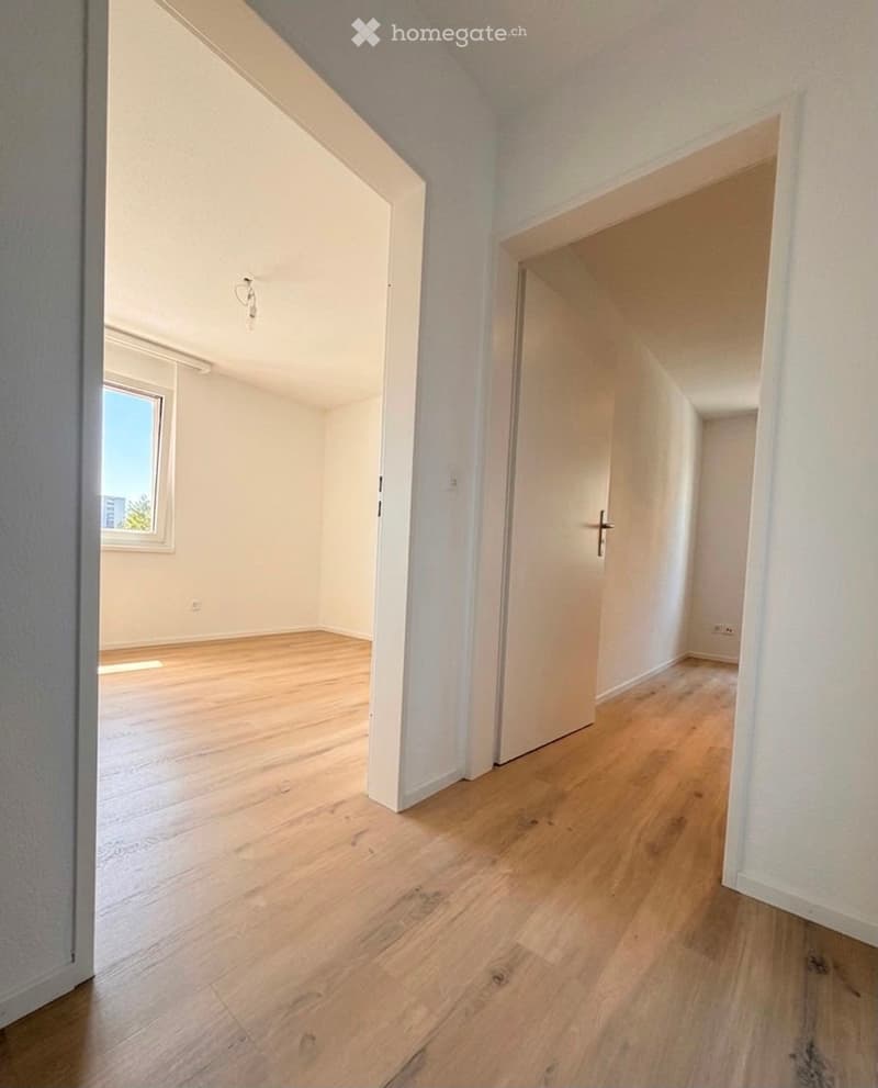 Empty room with wooden flooring, white walls, and a window letting in natural light. No furniture or equipment present.