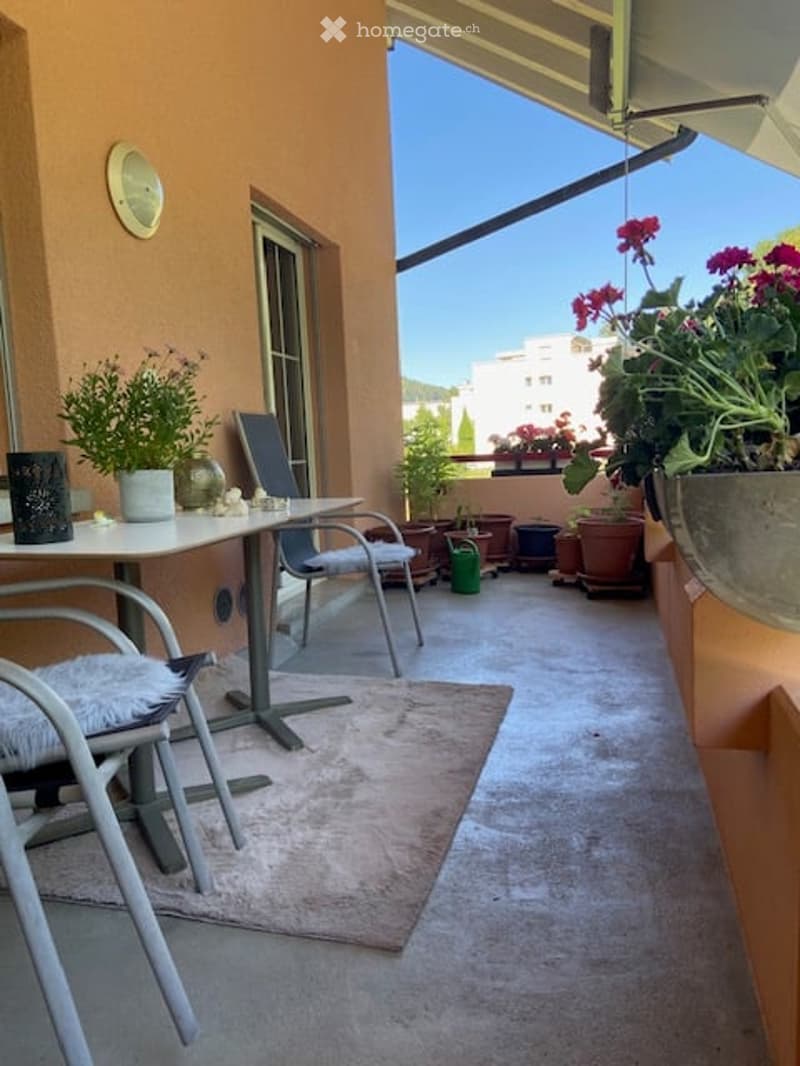 Balcony with outdoor furniture, potted plants, and a view of the city.