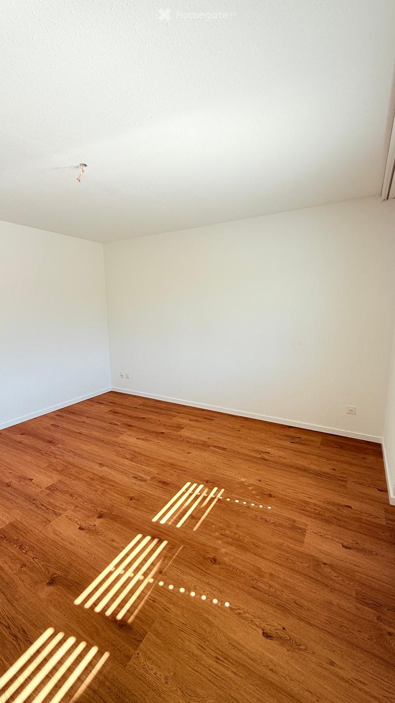 Empty room with light-colored walls and wooden flooring, no furniture or equipment visible.