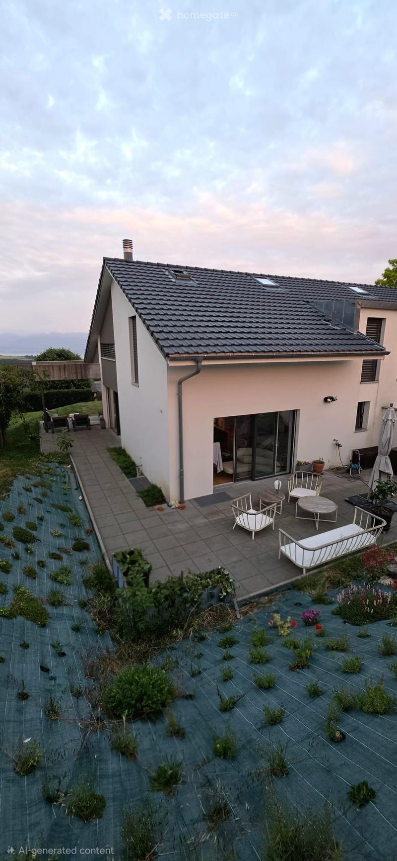 Modern house with a raised garden area, featuring a patio with white furniture, small plants, and a view of the surrounding landscape.