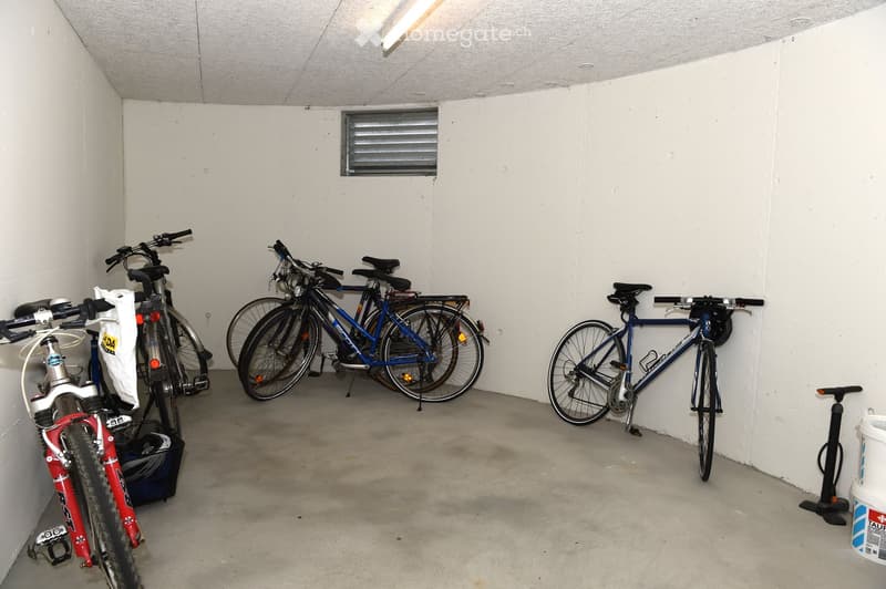 small room with bicycles and a pump