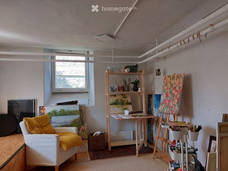 art studio, white walls, art pieces, wooden furniture, desk, painting supplies, white chair with yellow cushions, rug