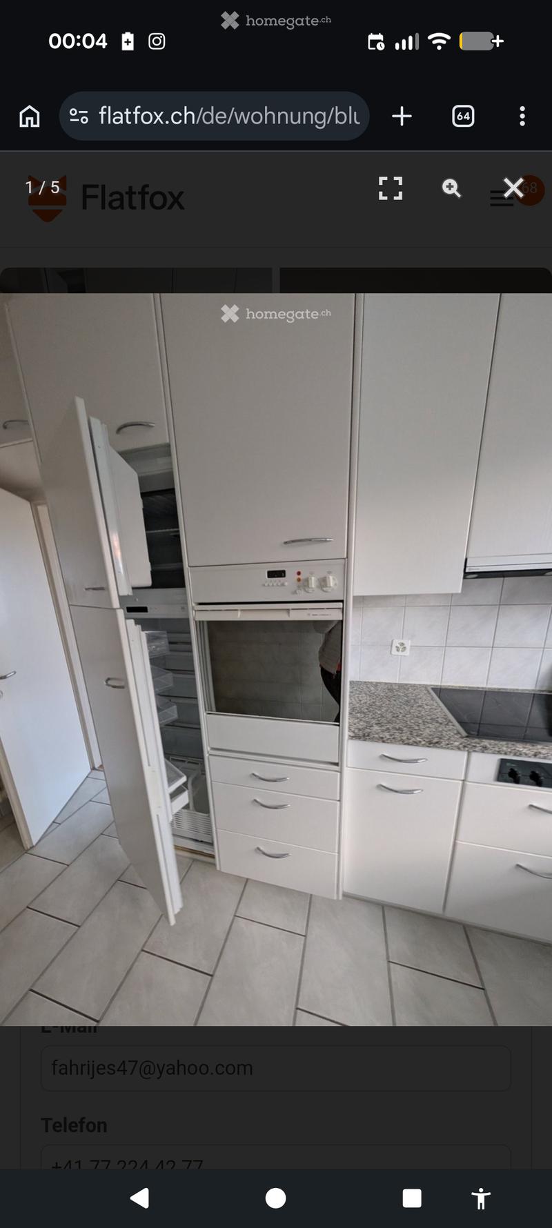 Modern kitchen with white cabinets, granite countertop, and built-in oven.